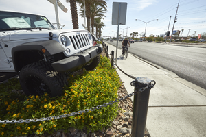 Auto dealership display and bicylist on West Sahara Avenue near Decatur Boulevard, looking east, Las Vegas, Nevada: digital photograph