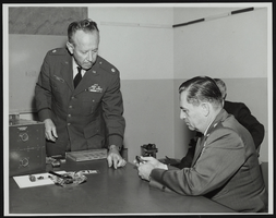 Howard Cannon views miniaturization samples in the Air Force Avionics Lab at Wright-Patterson Air Force Base, Ohio with Colonel L. O. Carroll demonstrating: photographic print