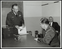 Howard Cannon views miniaturization samples in the Air Force Avionics Lab at Wright-Patterson Air Force Base, Ohio with Colonel L. O. Carroll demonstrating: photographic print