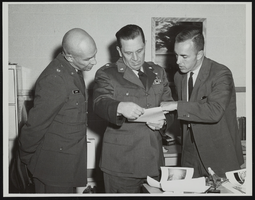 Reconnaissance photographs taken from an RF-4C aircraft during a recent test at the Air Force Missile Development Center are explained to Howard Cannon at the Holloman Air Force Base, New Mexico: photographic print