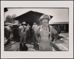 Clark County Fire Department Captain Ray Vasquez stands near other firefighters after putting out a residential fire: black-and-white photographs