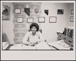 Delia Martinez sitting at her desk, where she directs the Nevada Equal Rights Commission: black-and-white photographs