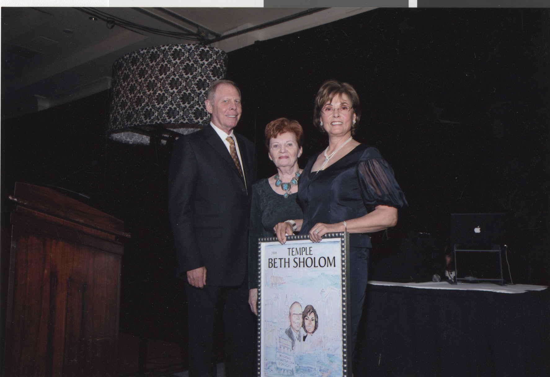 Photograph of Stuart and Flora Mason receiving framed artwork, April 2008