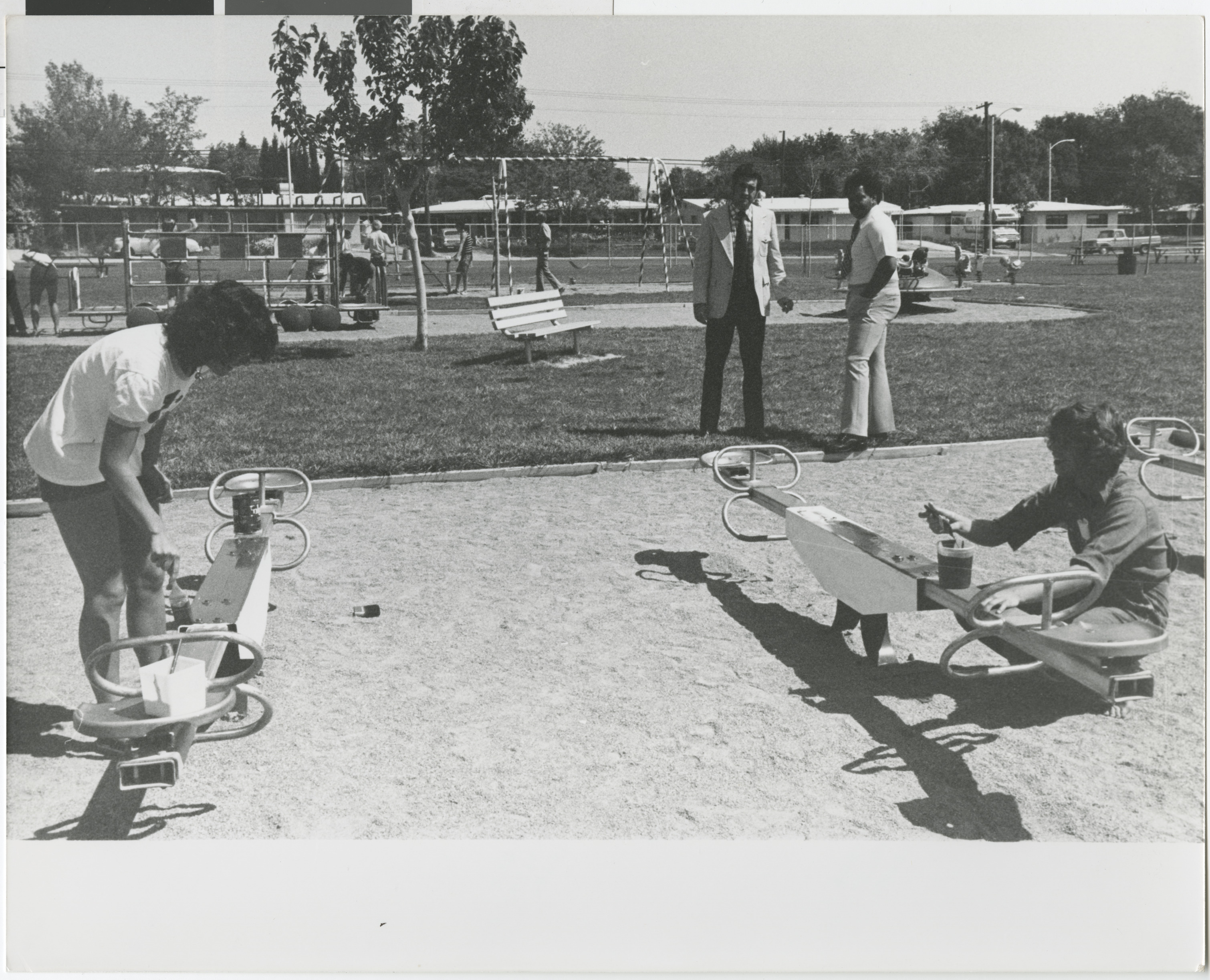 Photograph of Ron Lurie with community members painting playground equipment