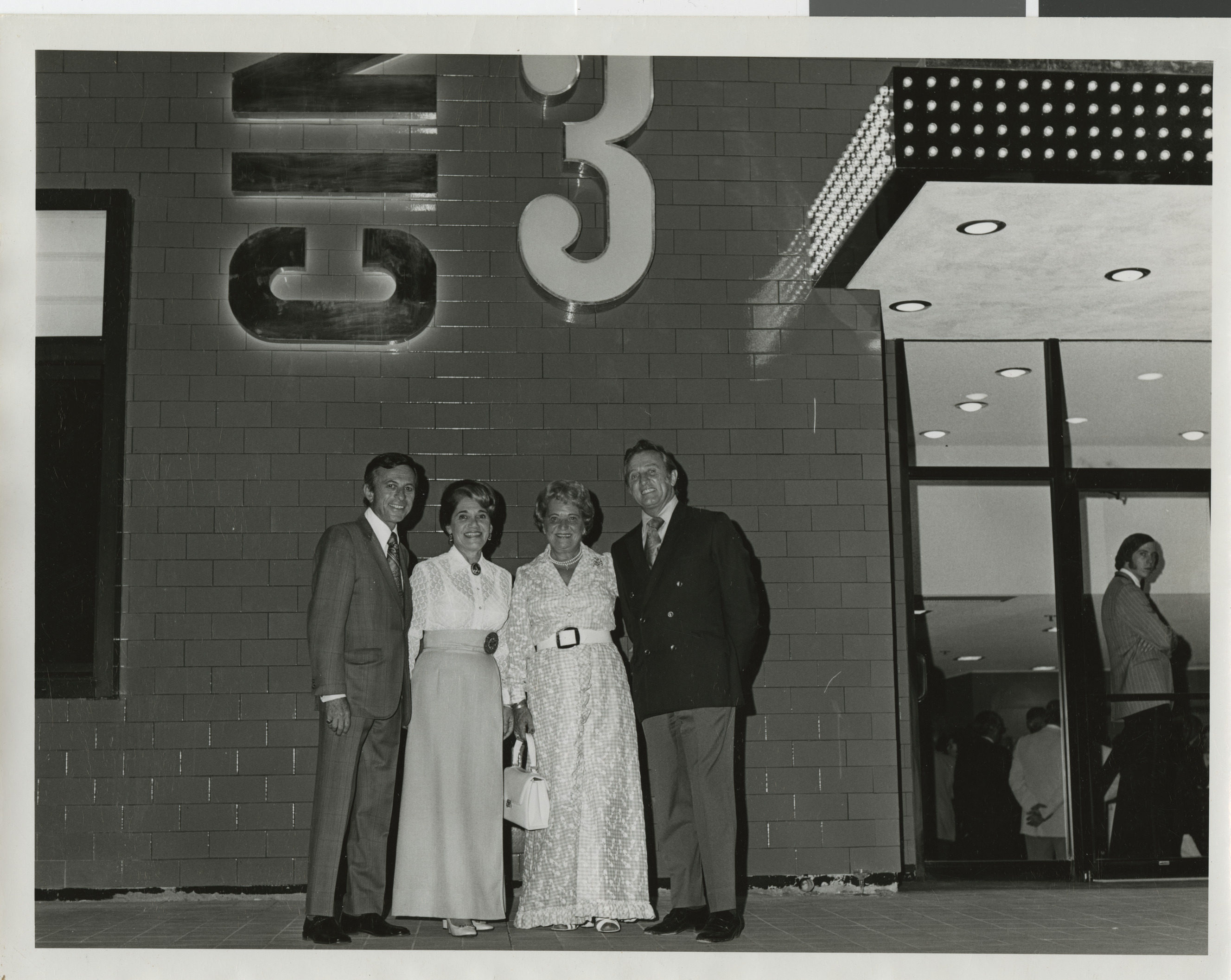 Photograph of Lloyd and Edythe Katz with unknown couple outside of Cinemas 1, 2, 3